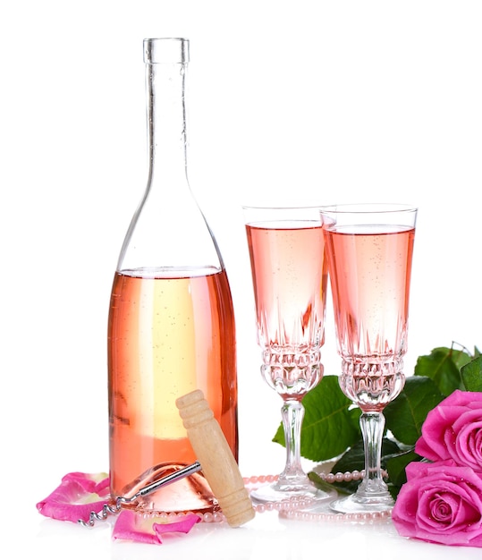 Composição com vinho rosa em copos, garrafa e rosas cor de rosa isoladas em branco
