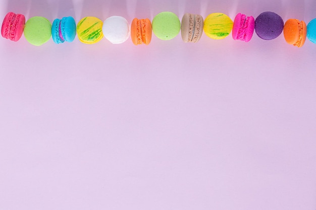 Composição criativa com envelope e bolo macaron ou macaroon na vista superior de fundo rosa pastel.