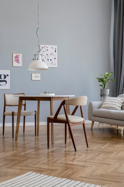 Composição criativa de design de interiores de sala de estar elegante escandinavo com molduras de pôster, sofá, cômoda de madeira, cadeira, plantas e acessórios. paredes neutras, piso em parquet.