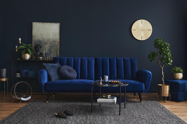 Composição criativa de design de interiores de sala de estar moderna com mesa de centro de prateleira de metal de sofá azul glamour e elegantes acessórios para casa parede azul escura encenação para casa modelo espaço de cópia