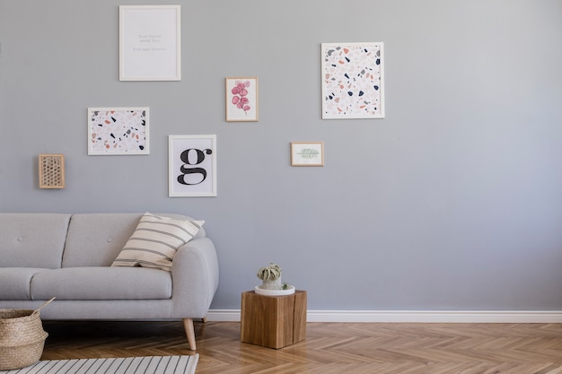 Composição criativa de design interior elegante de sala de estar escandinava com molduras de pôster, sofá, cômoda de madeira, cadeira, plantas e acessórios. paredes neutras, piso em parquet.