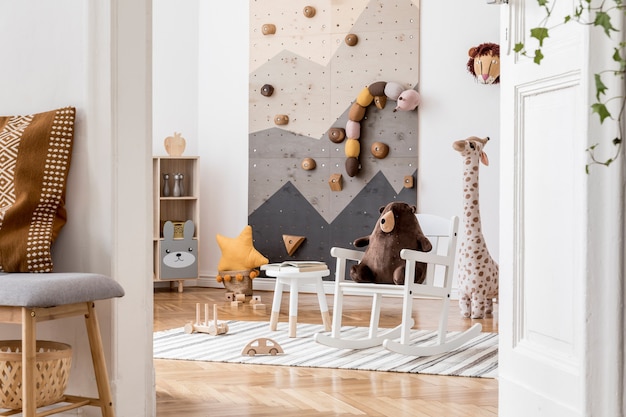 Composição criativa de interior elegante e aconchegante de quarto infantil com brinquedos de pelúcia sofá cômoda poltrona tapete e acessórios