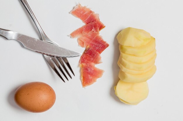 Composição crua de um prato tradicional de ovos e presunto de batatas de cozinha espanhola