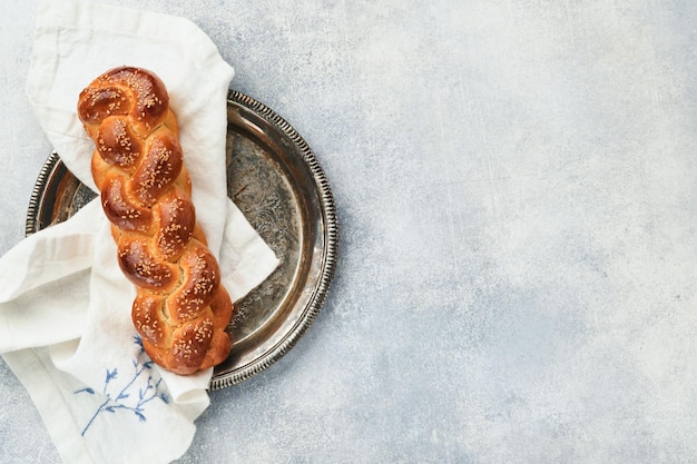 Composição da cerimônia do kidush de sábado pão de chalá pão de chalá trançado caseiro recém-assado para shabat e feriados em fundo cinza claro shabat shalom vista superior espaço para texto