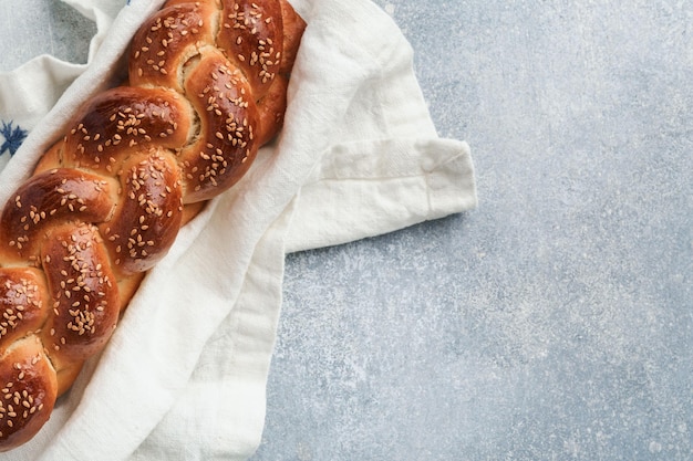 Composição da cerimônia do kidush de sábado Pão de chalá Pão de chalá trançado caseiro recém-assado para Shabat e feriados em fundo cinza claro Shabat Shalom Vista superior Espaço para texto