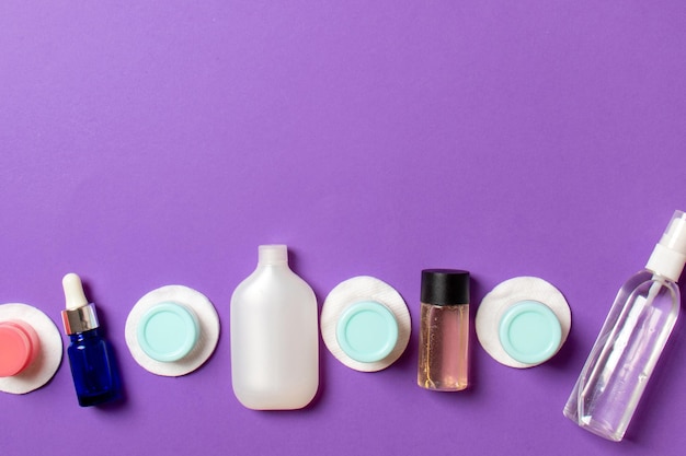 Foto composição da vista superior de pequenos frascos e frascos de viagem para produtos cosméticos em fundo colorido conceito de cuidados com a pele facial com espaço de cópia para o seu design