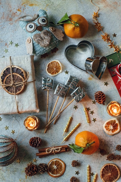 Composição de Ano Novo ou Natal com tangerinas laranjas secas canela presentes doces e brinquedos em mesa rústica leve