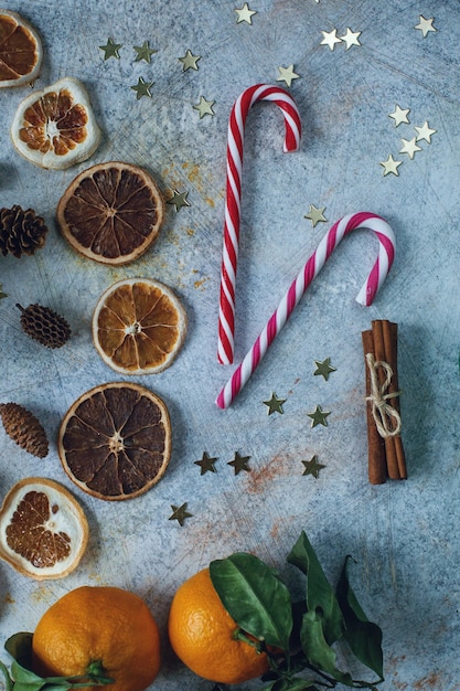 Composição de Ano Novo ou Natal com tangerinas laranjas secas canela presentes doces e brinquedos em mesa rústica leve