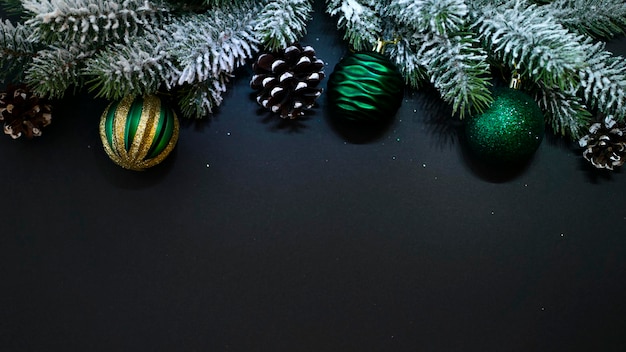 Composição de ano novo. Ramos de abeto, bolas e cones em um fundo preto