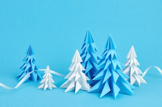 Composição de árvores de natal de origami em papel azul e branco