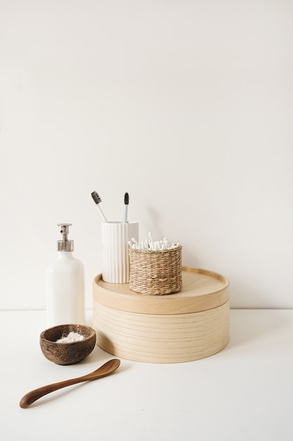 Composição de beleza e saúde com palitos em caixão de ratã, pó, escovas de dente, sabonete líquido na mesa branca