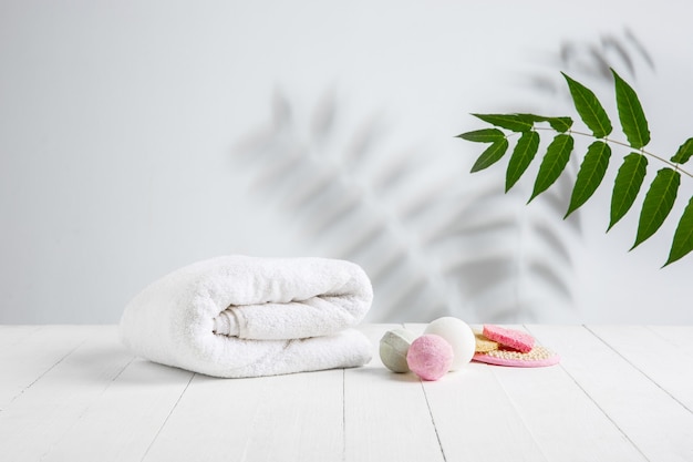 Composição de belo spa na mesa de massagem no centro de bem-estar, copyspace. acessórios para tratamentos relaxantes e cuidados pessoais. toalhas, óleos, soro, sais marinhos e esfoliantes. velas decorativas.