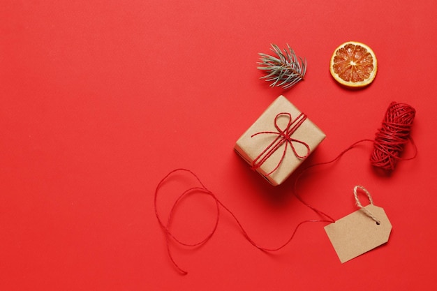 Composição de caixas de presente de artesanato e itens de Natal em um fundo vermelho. lugar para texto. Vista do topo.