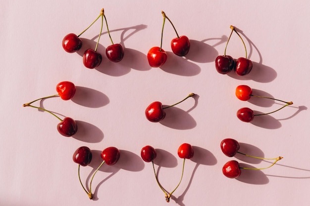 Composição de cerejas em um fundo rosa