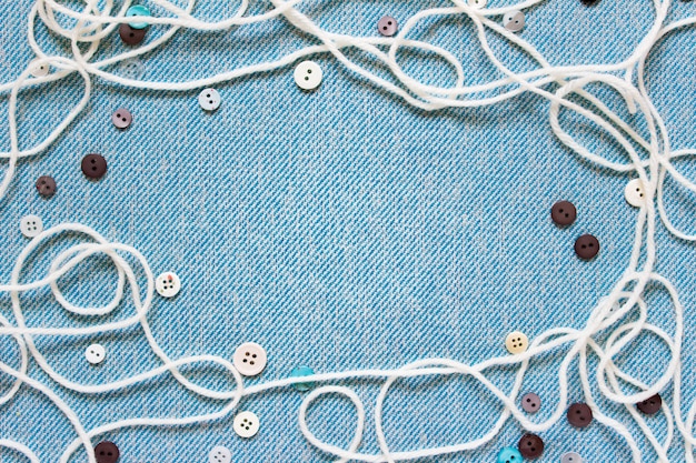 Composição de costura com botões de corda branca em tecido azul