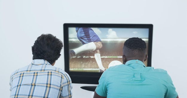 Composição de dois fãs de esportes do sexo masculino assistindo a uma partida de futebol na TV