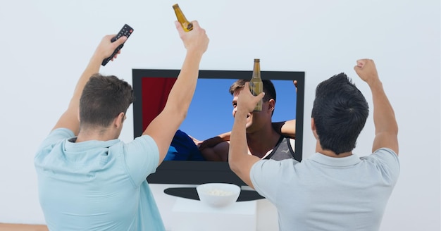 Composição de dois fãs de esportes do sexo masculino assistindo a uma partida de futebol na TV