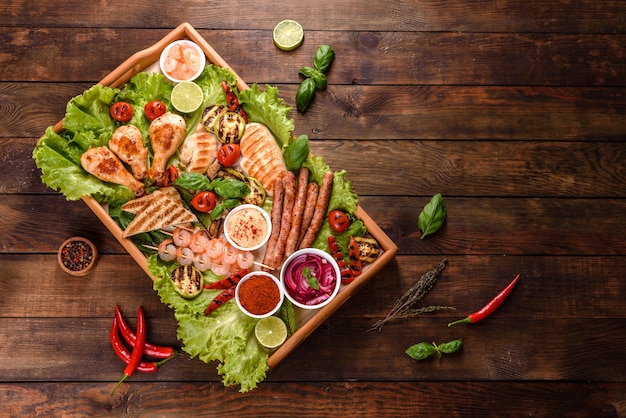 Composição de enchidos, frango, porco e camarão preparados na grelha, bem como vegetais preparados na grelha com especiarias e ervas aromáticas. Cozinhando em chamas