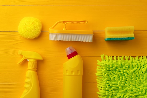 Foto composição de ferramentas de limpeza plana sobre fundo amarelo de madeira