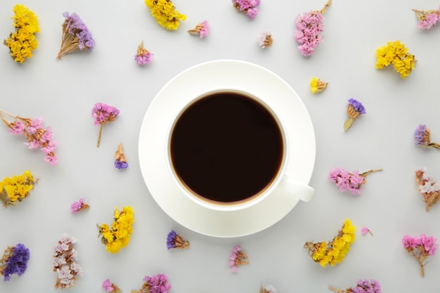 Composição de flores com xícara de café