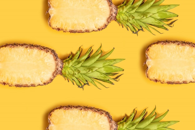 Composição de frutas de verão. abacaxis frescos metade cortada em fundo amarelo