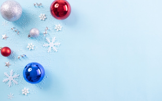 Composição de fundo de Natal. Vista superior da bola de Natal com flocos de neve sobre fundo pastel azul claro. Copie o espaço.