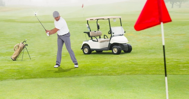 Composição de homem caucasiano jogando golfe com taco de golfe próximo ao carrinho de golfe