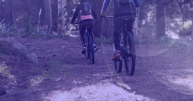 Composição de homem e mulher andando de bicicleta na floresta