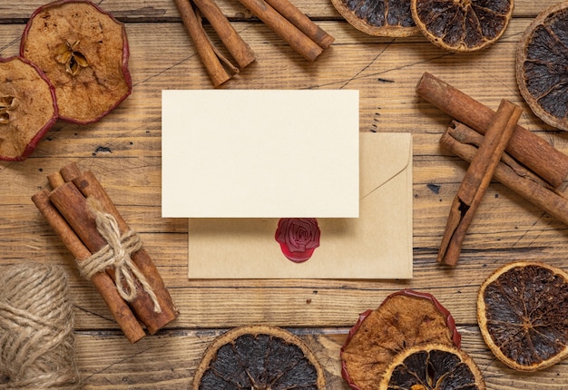 Composição de inverno com um cartão em branco e um envelope selado com especiarias e frutas secas