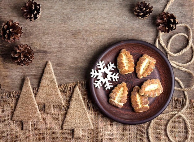 Composição de inverno rústico com biscoitos de Shortbread em um prato e pinhas