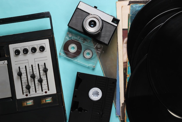 Foto composição de mídia retro plana leigos. gravador de fita equalizador, discos de vinil, câmera, vídeo e fita cassete em azul