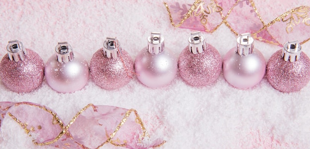 Composição de Natal Bola de férias de decoração rosa de Natal com fita em fundo rosa
