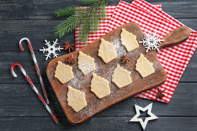 Composição de natal com biscoitos crus e bengalas doces na mesa de madeira