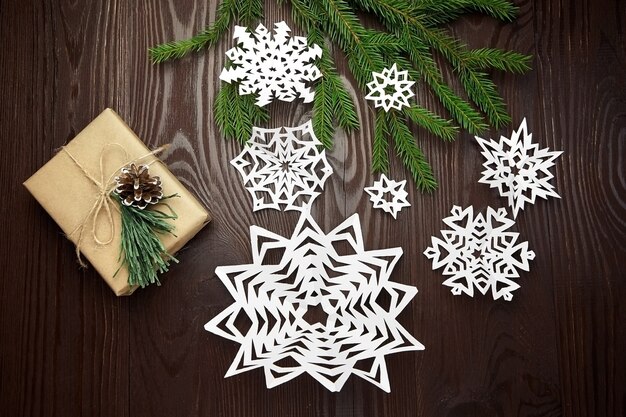 Composição de Natal com caixa de presente, flocos de neve de papel e galhos de pinheiros