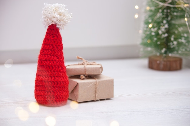 Composição de Natal com caixas, chapéu de Papai Noel e árvore de Natal.