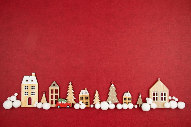 Composição de Natal com casas de madeira de brinquedo, sobre o fundo vermelho