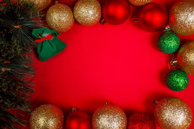 Composição de Natal com enfeites em fundo vermelho. Camada plana, vista superior, espaço de cópia. Fundo elegante minimalista para o espaço livre de design. Espaço para texto.