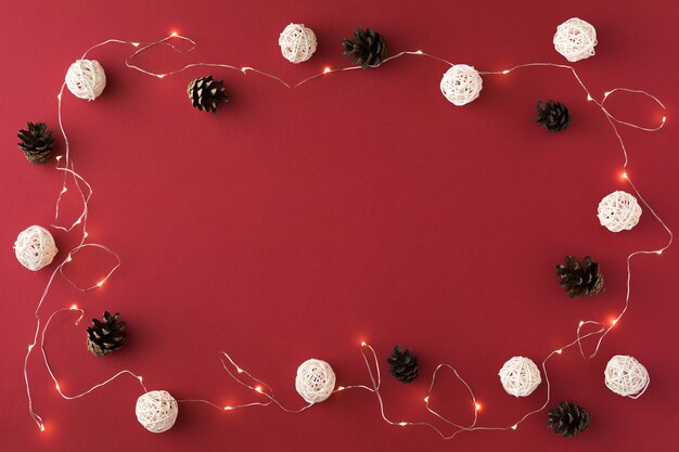 Composição de Natal com festão e bolas brancas no vermelho. Postura plana de Natal, inverno, ano novo