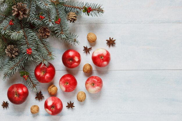 Composição de Natal com maçãs vermelhas, nozes, canela e outros ingredientes e acesso