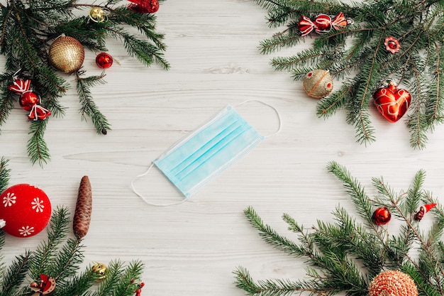 Composição de Natal com máscara em uma mesa de madeira branca com espaço de cópia