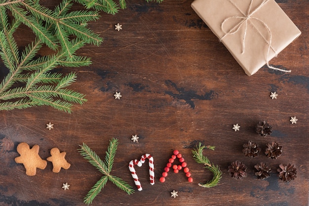 Composição de natal com presente e homem-biscoito na obscuridade de madeira.