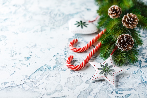Composição de Natal com ramo de abeto, decorações de Natal, bastões de doces