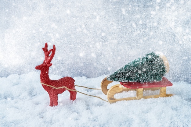 Composição de Natal com veados e pinheiros em trenó na neve. Copie o espaço