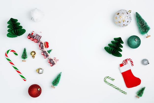 Composição de Natal Condecorações vermelhas e verdes de abeto em fundo branco Conceito de feriados de inverno de ano novo de Natal Espaço plano para cópia