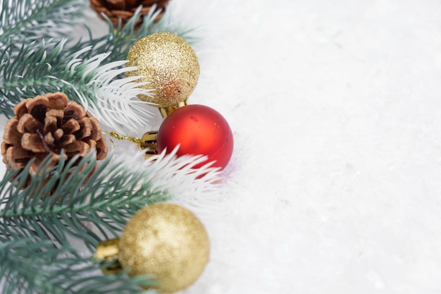 Composição de Natal da árvore de natal brinquedo bola vermelha e dourada neve fundo cone de galho de árvore