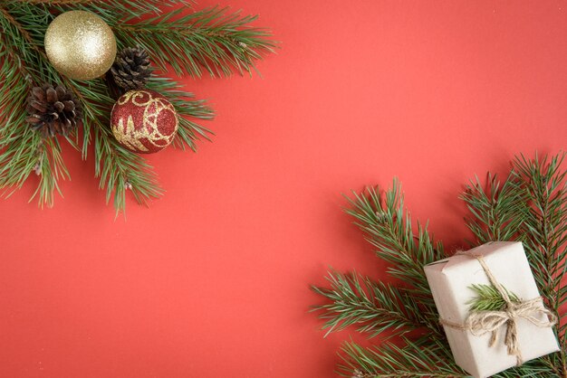 Composição de Natal de caixa de presente, ramos de abeto, cones, laço vermelho no vermelho.