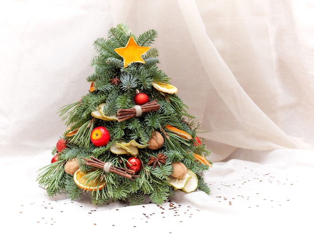 Composição de Natal de galhos de árvore do abeto, fatias de laranja e maçã, nozes, anis e bolas. Close-up shot. Em fundo bege