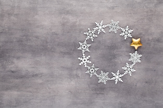 Composição de Natal Decorações de grinalda de flocos de neve branca em cinza.