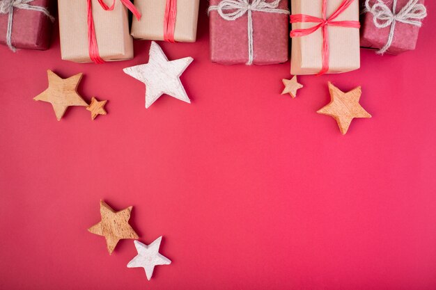 Composição de natal. decorações de natal vermelho, estrelas e caixas de presente em fundo vermelho