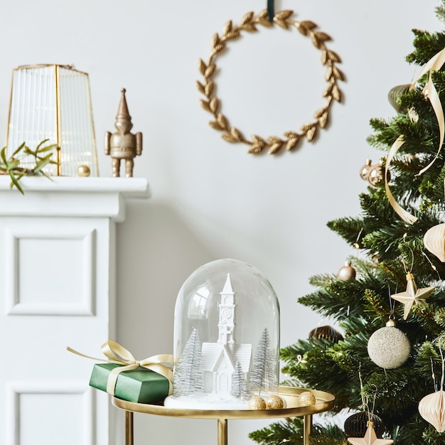 Foto composição de natal elegante no interior da sala de estar com chaminé branca, árvore de natal e grinalda, estrelas, presentes e decoração. papai noel está chegando. modelo.